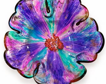 May include: A flower-shaped bowl featuring a vibrant swirl of purple, magenta, and teal colours radiating from the centre. The centre of the bowl is filled with textured, metallic copper-coloured flakes, creating a distinct contrast against the colours.