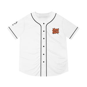 Peut inclure: Maillot de baseball blanc avec garniture et boutons noirs. Le maillot porte l'inscription "Jesus Saves" en orange sur le devant. Les manches et le col sont bordés de noir. Un petit logo est visible sur la manche gauche.