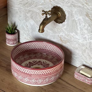 Puede incluir: Un juego de tres tazas de cerámica con un acabado moteado y mate. Las tazas son en tonos crema, gris claro y gris oscuro. Cada taza tiene un diseño simple y minimalista y un asa redondeada. Las tazas están apiladas una encima de otra.