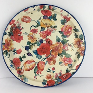 Può includere: Vassoio rotondo da portata con sfondo color crema e design floreale. I fiori sono in tonalità di rosso, giallo e arancione, con foglie verdi e un bordo blu. Il vassoio ha il nome "Christina" stampato.