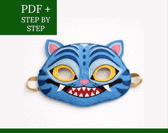 May include: A blue felt mask in the shape of a tiger's face with yellow eyes, white fangs, and a red mouth. The mask has gold elastic straps. Text on the image reads "PDF + STEP BY STEP" and "FELT DESIGN WONDER FELT STORY".