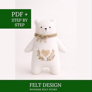 Op de afbeelding: Een witte vilten beer met een jute touw kraag en een hartvormig ontwerp op de borst. De beer heeft kleine zwarte ogen en een gestikte neus. De afbeelding bevat de tekst "PDF + STEP BY STEP" en "FELT DESIGN WONDER FELT STORY".