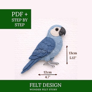 Pode incluir: Um pássaro de feltro azul com rosto branco e bico preto. O pássaro de feltro tem 13 cm de altura e 12 cm de largura. O texto "PDF + STEP BY STEP" e "FELT DESIGN" está incluído.