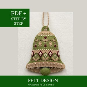 May include: A bell-shaped felt ornament featuring olive green and beige fabric with intricate embroidery in maroon, white, and green. The design includes floral motifs, geometric diamonds, and small white beads. A jute twine loop is attached at the top.