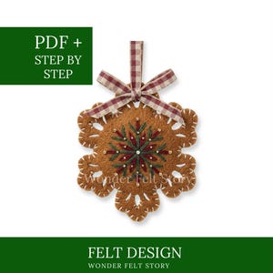 May include: A brown felt snowflake ornament featuring white blanket stitching along the edges, dark green and red embroidery in the center, and a red and white gingham ribbon bow at the top. The text reads PDF + STEP BY STEP and FELT DESIGN WONDER FELT STORY.