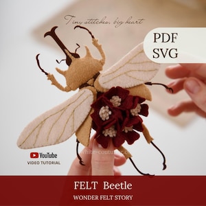 Puede incluir: Un escarabajo de fieltro color canela con alas beige claro que presentan costuras doradas y un racimo de flores de fieltro rojo oscuro en su espalda. La imagen incluye el texto: Tiny stitches, big heart, PDF, SVG, YouTube VIDEO TUTORIAL, FELT Beetle, WONDER FELT STORY.