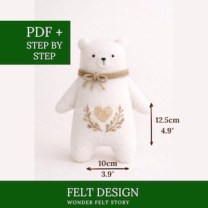 Può includere: Un orsetto di feltro bianco con un fiocco di spago di iuta e un ricamo a forma di cuore. L'orsetto è alto 12,5 cm e largo 10 cm. Il testo sull'immagine recita "PDF + STEP BY STEP" e "FELT DESIGN".
