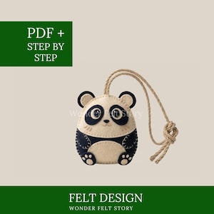May include: A handmade felt panda ornament with a beige body, black accents, and a jute string for hanging. The design includes the text "PDF + STEP BY STEP" and "FELT DESIGN WONDER FELT STORY".