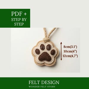 May include: A felt paw print pendant with a beige and brown design, measuring 3.1" to 4.7" in height. The pendant hangs from a natural rope. The image includes the text "PDF + STEP BY STEP" and "FELT DESIGN WONDER FELT STORY".