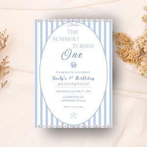 Puede incluir: Una invitación a rayas azules y blancas con el texto "The Summer I Turned One". La invitación tiene un marco ovalado con el texto "Emily's 1st Birthday". La invitación está decorada con perlas y gráficos de conchas marinas.