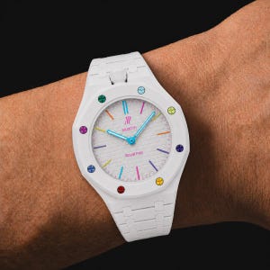 Könnte beinhalten: Eine weiße Armbanduhr mit einem strukturierten weißen Zifferblatt, das die Aufschrift AP, swatch und Royal Pop trägt. Die Lünette ist mit acht bunten, kreisförmigen Markierungen versehen. Die Zeiger sind hellblau und die Indizes sind dünne Linien.