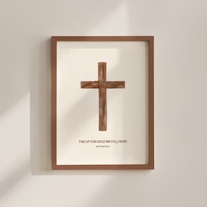 Puede incluir: Obra de arte enmarcada con una cruz de madera sobre un fondo crema. La cruz es de color marrón natural, con vetas de madera visibles. El texto "TAKE UP YOUR CROSS AND FOLLOW ME" está impreso debajo, con "MATTHEW 16:24" debajo.