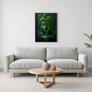 A framed print of a green Buddha head in a forest hangs on a white wall above a light gray sofa and a round wooden coffee table.