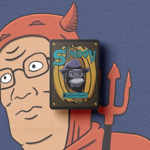 Puede incluir: Un pin rectangular con un gorila de dibujos animados con un sombrero fedora, sobre un fondo dorado y marr&oacute;n. El pin tiene la palabra "Smoov" en verde azulado y el identificador de Instagram "@SmoovGorilla". El fondo es de tela azul.