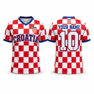 Pode incluir: Uma camisola de manga curta com decote em V e um padr&atilde;o axadrezado vermelho e branco. A frente apresenta o texto CROATIA e um emblema. As costas mostram o texto YOUR NAME acima do n&uacute;mero 10 e um pequeno emblema no decote com rebordo azul.