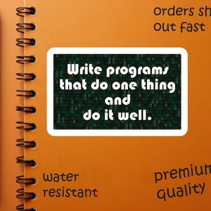 Pu&ograve; includere: Un quaderno arancione a spirale con una penna nera sul lato sinistro. Un adesivo bianco al centro con la scritta "Write programs that do one thing and do it well". Il quaderno ha anche le parole "water resistant" e "premium quality".