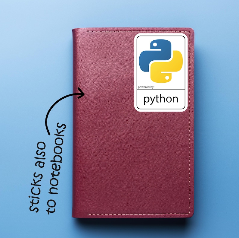 May include: A burgundy notebook with a white sticker featuring the Python programming language logo. The sticker has a blue and yellow snake icon and the word "python" below. The text "sticks also to notebooks" is written on the left.