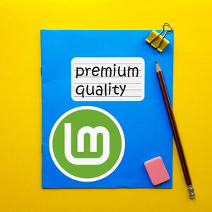 May include: A blue notepad with a green and white logo and the words "premium quality" on a white sticker. A pencil, pink eraser, and yellow binder clip are also on the yellow background.