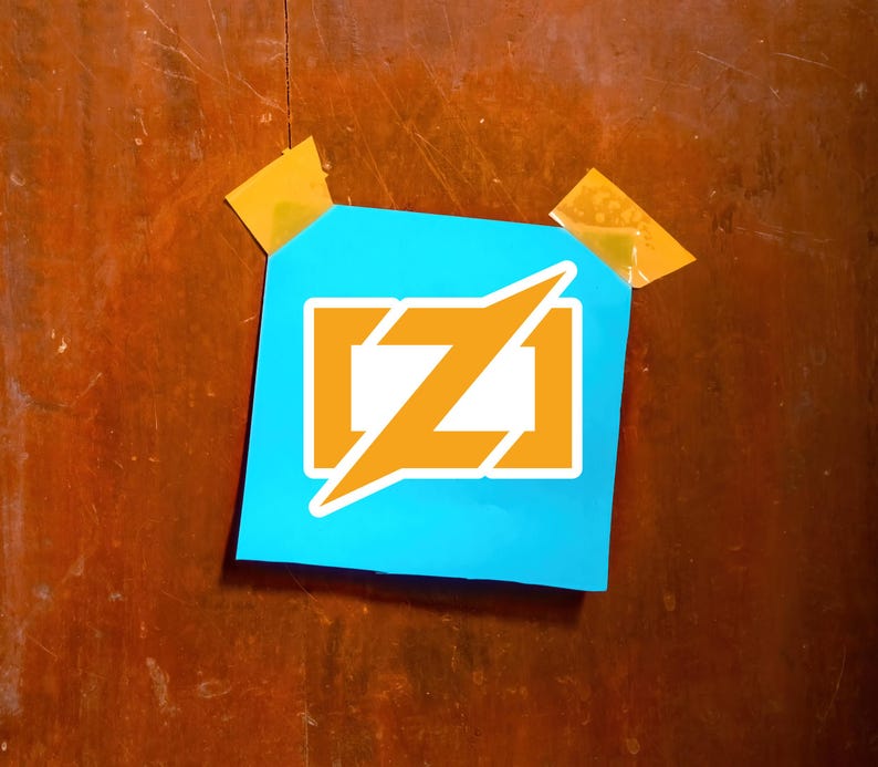 Puede incluir: Un cuadrado azul con un logotipo naranja y blanco, pegado a una superficie de madera con cinta adhesiva. El logotipo presenta una letra "Z" naranja estilizada dentro de un rect&aacute;ngulo blanco, con un rayo naranja.