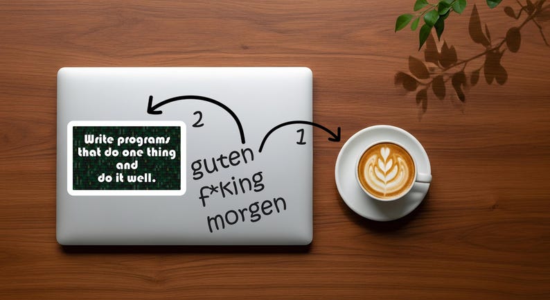 Pu&ograve; includere: Un laptop con un adesivo che recita "Write programs that do one thing and do it well." Accanto al laptop c'&egrave; una tazza di caff&egrave; con latte art. Le parole "guten f*king morgen" sono anche sul laptop.