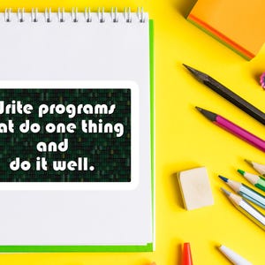 Pu&ograve; includere: Un taccuino bianco a spirale con bordo verde, con un adesivo che recita "Scrivi programmi che fanno una cosa e falla bene". Matite, una gomma e post-it sono sparsi su una superficie gialla.