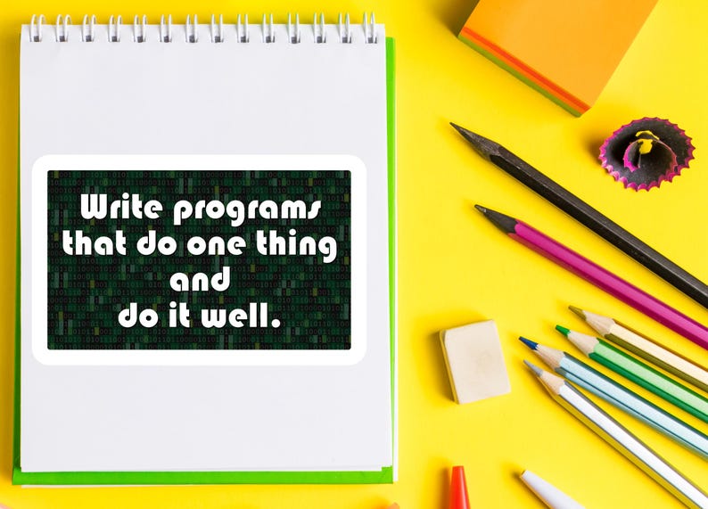 Pu&ograve; includere: Un taccuino bianco a spirale con bordo verde, con un adesivo che recita "Scrivi programmi che fanno una cosa e falla bene". Matite, una gomma e post-it sono sparsi su una superficie gialla.