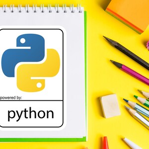 May include: A white spiral-bound notebook with a green border displays a Python logo in blue and yellow, with the word "python" below. Pencils, an eraser, and a pencil sharpener are scattered on a yellow surface.