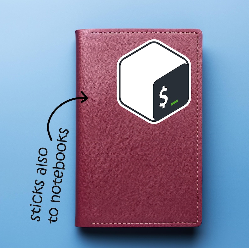 May include: A burgundy notebook with a white and black sticker featuring a dollar sign and a green underscore. The sticker is in the shape of a hexagon. Text on the image says "sticks also to notebooks". The notebook is on a blue background.
