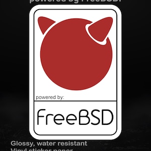 May include: A water-resistant vinyl sticker with a glossy finish. It displays the FreeBSD logo: a red devil-like figure within a white-bordered rectangle. The text "powered by FreeBSD!" is at the top, with "powered by:" and "FreeBSD" below.