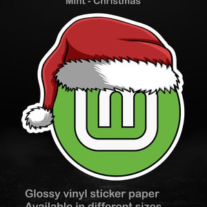 May include: A glossy vinyl sticker featuring a green and white logo wearing a red Santa hat with white trim. The sticker has the text "Mint - Christmas" at the top and "Glossy vinyl sticker paper Available in different sizes" at the bottom.