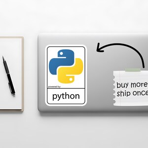 May include: A laptop with a Python sticker featuring a blue and yellow logo. A notepad with the text "buy more, ship once" is attached with tape. A pen and notepad are on the left.