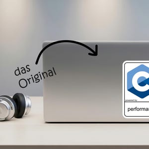 May include: A silver laptop with a sticker featuring a blue and white C++ logo and the text "performance." The words "das Original" are written in black. Silver headphones are on the table.