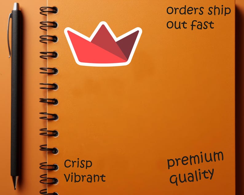 Op de afbeelding: Een oranje spiraalgebonden notitieboek met een zwarte pen aan de linkerkant. Een rode en witte kroonsticker staat in het midden. Tekst bevat "orders ship out fast", "Crisp Vibrant" en "premium quality".