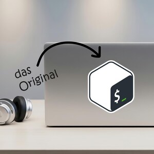 May include: A silver laptop with a sticker featuring a white and dark teal hexagonal design with a dollar sign and a green underscore. The text "das Original" is above the laptop. Silver headphones are on the table.