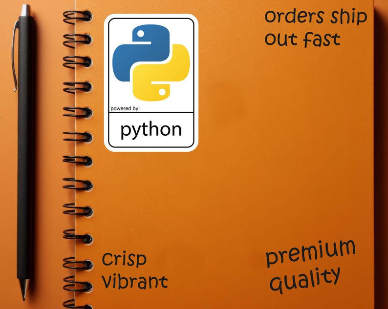 May include: An orange spiral notebook with a black pen and a Python sticker. The sticker features a blue and yellow logo with the word "python" below. The notebook has the words "Crisp Vibrant" and "premium quality".