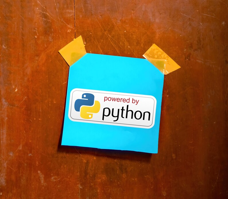 May include: A bright blue sticky note with the words "powered by python" printed on a white label. The Python logo is displayed in blue and yellow. The note is affixed to a wooden surface with two pieces of yellow tape.