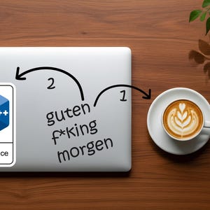 May include: A laptop with a C++ logo sticker and the words "guten f*king morgen" written on it. A cup of coffee with latte art sits to the right. The items are on a wooden surface.