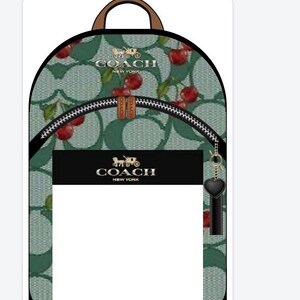 May include: A backpack featuring a light green background with a repeating Coach logo pattern and a red cherry print. It includes a brown top handle, a front zippered pocket with a black rectangular patch displaying the Coach New York logo, and a black heart-shaped charm.