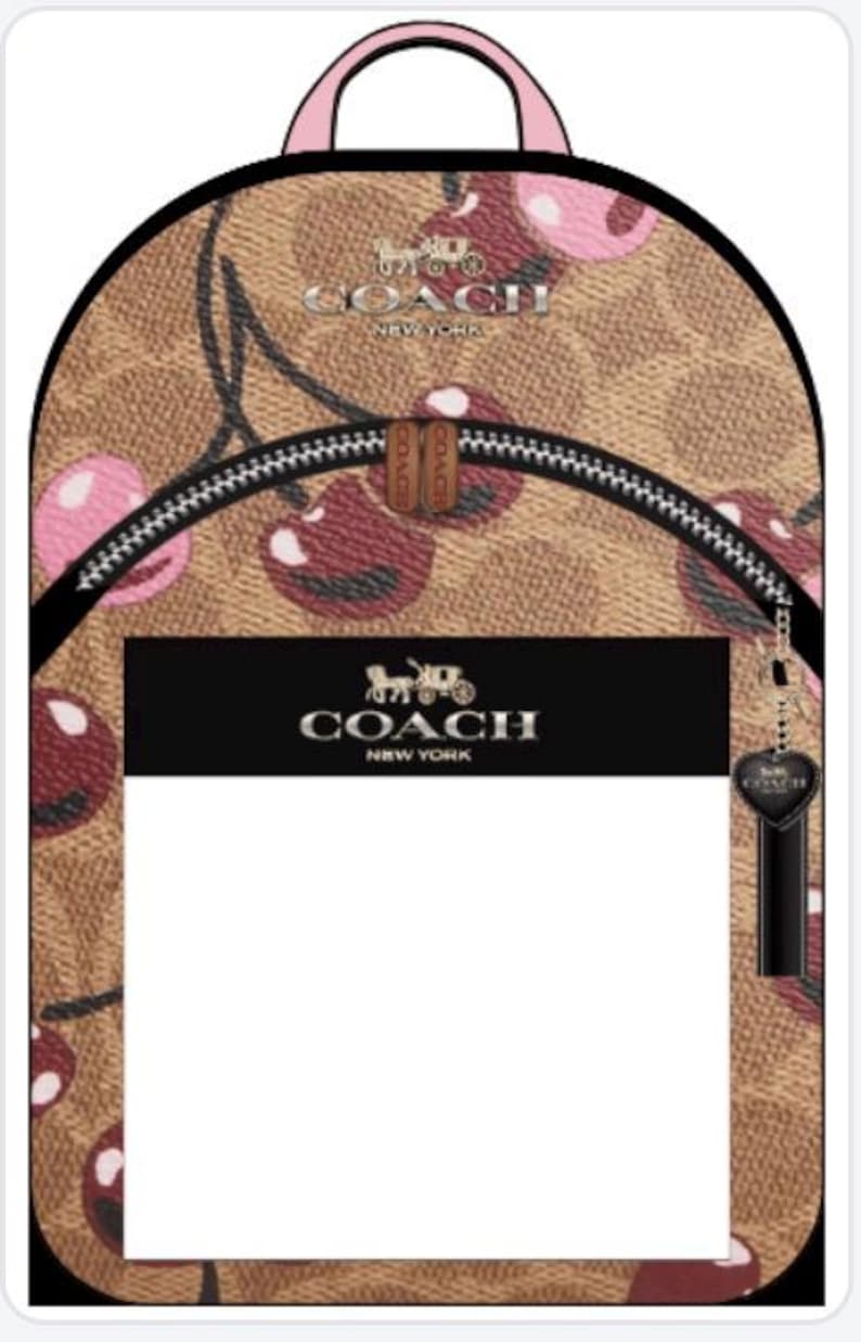 May include: A tan backpack featuring the Coach signature logo pattern with a pink cherry print. The bag has a top handle, a front zippered pocket with a black rectangular panel displaying the Coach New York logo, and a black heart-shaped charm.