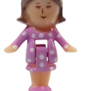 May include: A miniature plastic doll with brown hair and a smiling face. The doll is dressed in a pink dress with white polka dots and pink shoes. The doll's arms are outstretched.