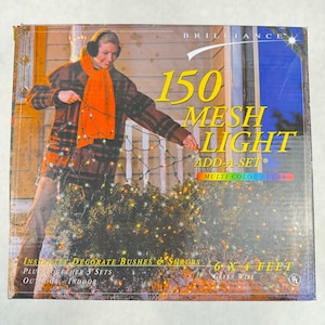 May include: A box of 150 Mesh Light string lights with multi-color bulbs. The packaging shows a person decorating a bush with the lights. The box reads "Instantly decorate bushes & shrubs" and "6 x 4 feet".
