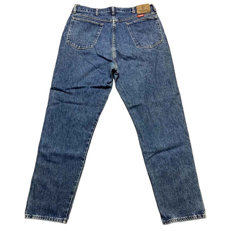 May include: Blue denim jeans with a classic five-pocket design. The jeans have a straight leg cut and a faded wash. The back features two pockets and a leather patch with the brand name. A timeless wardrobe staple.