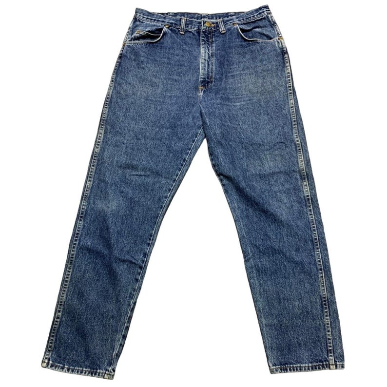 May include: Blue denim jeans with a classic five-pocket design. The jeans have a straight leg cut and a button and zipper closure. The denim has a faded, worn look.