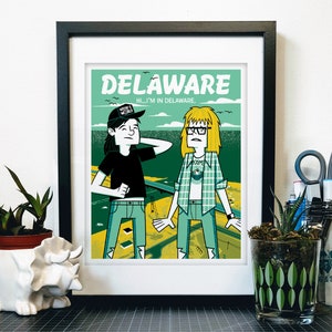 Op de afbeelding: Een groene en gele illustratie van twee mensen die voor een weg staan. De tekst "DELAWARE" staat bovenaan de afbeelding. De tekst "HI...I'M IN DELAWARE." staat onder het woord "DELAWARE". Een persoon draagt een zwart shirt met een zwarte hoed waarop "MAKE IT WEIRD" staat. De andere persoon draagt een groen-wit geruit overhemd.
