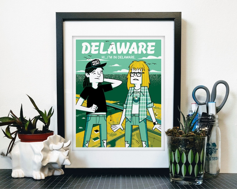 Op de afbeelding: Een groene en gele illustratie van twee mensen die voor een weg staan. De tekst "DELAWARE" staat bovenaan de afbeelding. De tekst "HI...I'M IN DELAWARE." staat onder het woord "DELAWARE". Een persoon draagt een zwart shirt met een zwarte hoed waarop "MAKE IT WEIRD" staat. De andere persoon draagt een groen-wit geruit overhemd.