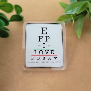 May include: A clear, rectangular sticker with the text "E FP - I - LOVE BOBA" in a stylized eye chart design. The words are in black, green, and red, with "Emotional Support Beverage" below.