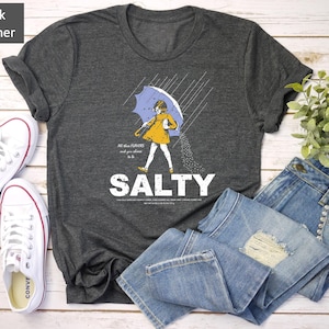 Add coastal charm to your outfit with this Salty Girl Graphic Tee. 🌴 A retro summer t-shirt designed for women who love the ocean breeze. Soft cotton blend, relaxed fit, and faded vintage style. Ideal gift for her or beach vacation outfit!