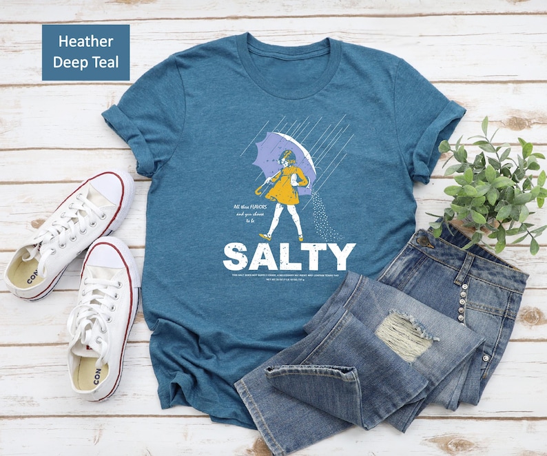 Sassy meets soft! ✨ Our Salty Girl Shirt blends vintage vibes with modern comfort. Made for sunny days and salty hair, this trendy graphic tee is your new favorite summer essential. Perfect casual top or thoughtful gift for her!