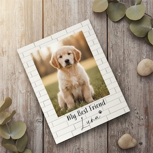 May include: A white brick-style photo frame with a picture of a golden retriever puppy. The text "My Best Friend Luna" is printed at the bottom of the frame, with a paw print symbol. The puppy is sitting on grass.