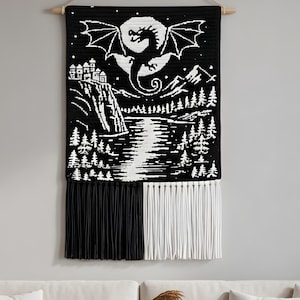 Peut inclure: Tapisserie en noir et blanc représentant un dragon aux ailes déployées sur un ciel nocturne. Le motif comprend un château, des montagnes et une scène de rivière. La moitié inférieure est ornée de franges noires et blanches.